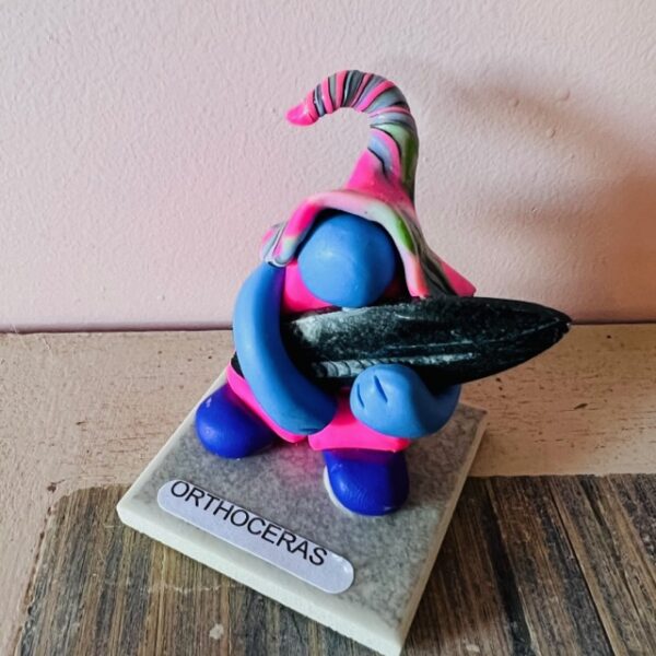 Ce petit Gnome tient dans ses bras une pierre ORTHOCERAS. du Maroc. - Boutique de pierres et minéraux La Porte des Secrets