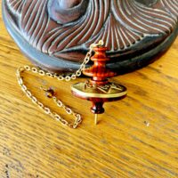 Pendule Mystica bois précieux et laiton - forme géométrique étoile à 7 branches - dimensions : 4 x 5 cm, poids : 20 gr - Boutique ésotérique La Porte des Secrets