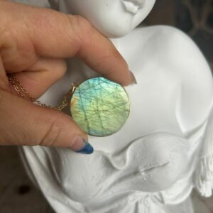 Pendentif en labradorite forme Ronde, style galette plate en provenance de Madagascar. dimension : 3.5 cm., épaisseur environ 3 mm. Cercle et bélière doré. Boutique Minéraux du Monde La Porte des Secrets