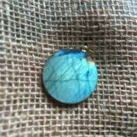 Pendentif en labradorite forme Ronde, style galette plate en provenance de Madagascar. dimension : 3.5 cm., épaisseur environ 3 mm. Cercle et bélière doré. Boutique Minéraux du Monde La Porte des Secrets