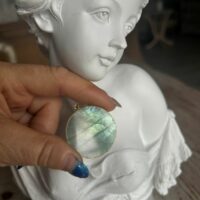 Pendentif en labradorite forme Ronde, style galette plate en provenance de Madagascar. dimension : 3.5 cm., épaisseur environ 3 mm. Cercle et bélière doré. Boutique Minéraux du Monde La Porte des Secrets