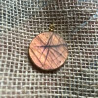 Pendentif en labradorite forme Ronde, style galette plate en provenance de Madagascar. dimension : 3.5 cm., épaisseur environ 3 mm. Cercle et bélière doré. Boutique Minéraux du Monde La Porte des Secrets