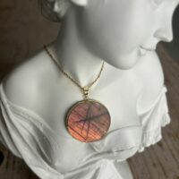 Pendentif en labradorite forme Ronde, style galette plate en provenance de Madagascar. dimension : 3.5 cm., épaisseur environ 3 mm. Cercle et bélière doré. Boutique Minéraux du Monde La Porte des Secrets