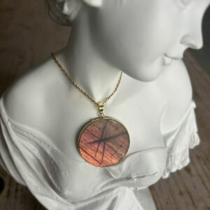 Pendentif en labradorite forme Ronde, style galette plate en provenance de Madagascar. dimension : 3.5 cm., épaisseur environ 3 mm. Cercle et bélière doré. Boutique Minéraux du Monde La Porte des Secrets